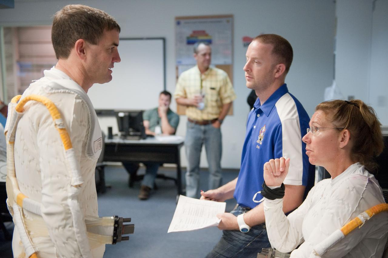 Photograph final space shuttle crew training session in the NBL with STS-135 Mission Specialists Sandy Magnus & Rex Walheim. STS-135 Commander Chris Ferguson serves as Intravehicular suit-up lead, Pilot Doug Hurley serves as robotic arm operator. Mission Specialists Sandy Magnus & Rex Walheim in the water. Photo Date: June 13, 2011. Location: NBL - Pool Topside. Photographer: Robert Markowitz