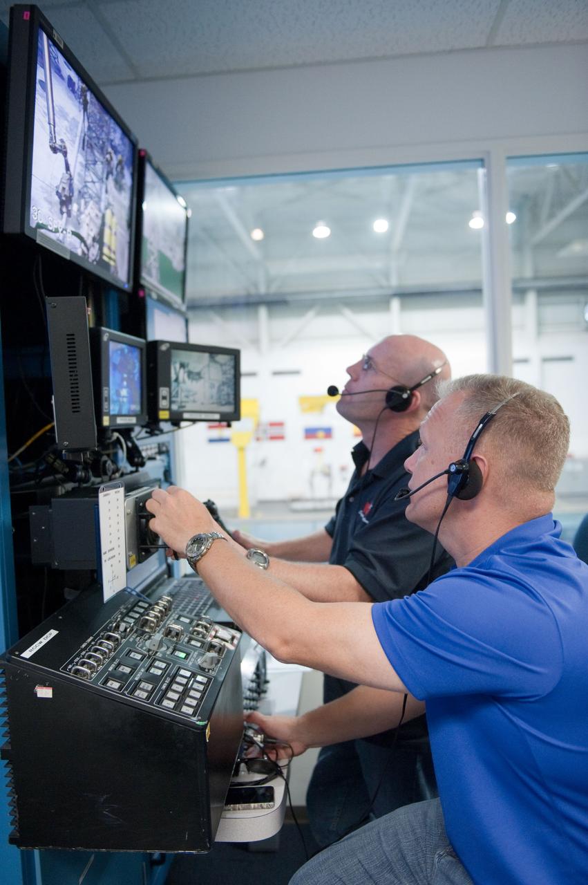 JSC2011-E-054080 (13 June 2011) --- NASA astronaut Doug Hurley (foreground), STS-135 pilot, participates in a training session in the simulation control area in the Neutral Buoyancy Laboratory (NBL) at the Sonny Carter Training Facility near NASA's Johnson Space Center. Photo credit: NASA