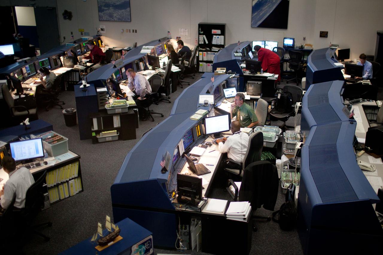 JSC2011-E-059386 (11 May 2011) --- In this high-angle wide shot, STS-135 flight director Kwatsi Alibaruho, (center with back toward camera), and astronaut Steve Robinson (center, facing camera), CAPCOM, work in the Mission Control Center at NASA?s Johnson Space Center during a simulation exercise with the crew on May 11, 2011. Photo credit: NASA Photo/Houston Chronicle, Smiley N. Pool