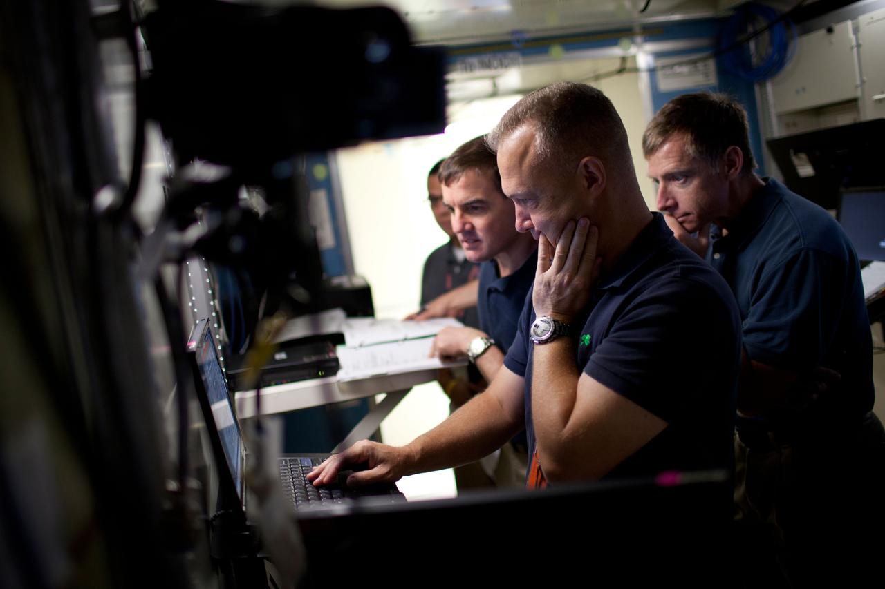 NASA astronauts Rex Walheim, Doug Hurley and Chris Ferguson work on computers in an exercises to overcome a power loss on the International Space Station as the crew of STS-135, the final space shuttle mission, trains in the Space Station Training Facility at the Johnson Space Center on Thursday, May 19, 2011, in Houston. ( NASA Photo / Houston Chronicle, Smiley N. Pool ).