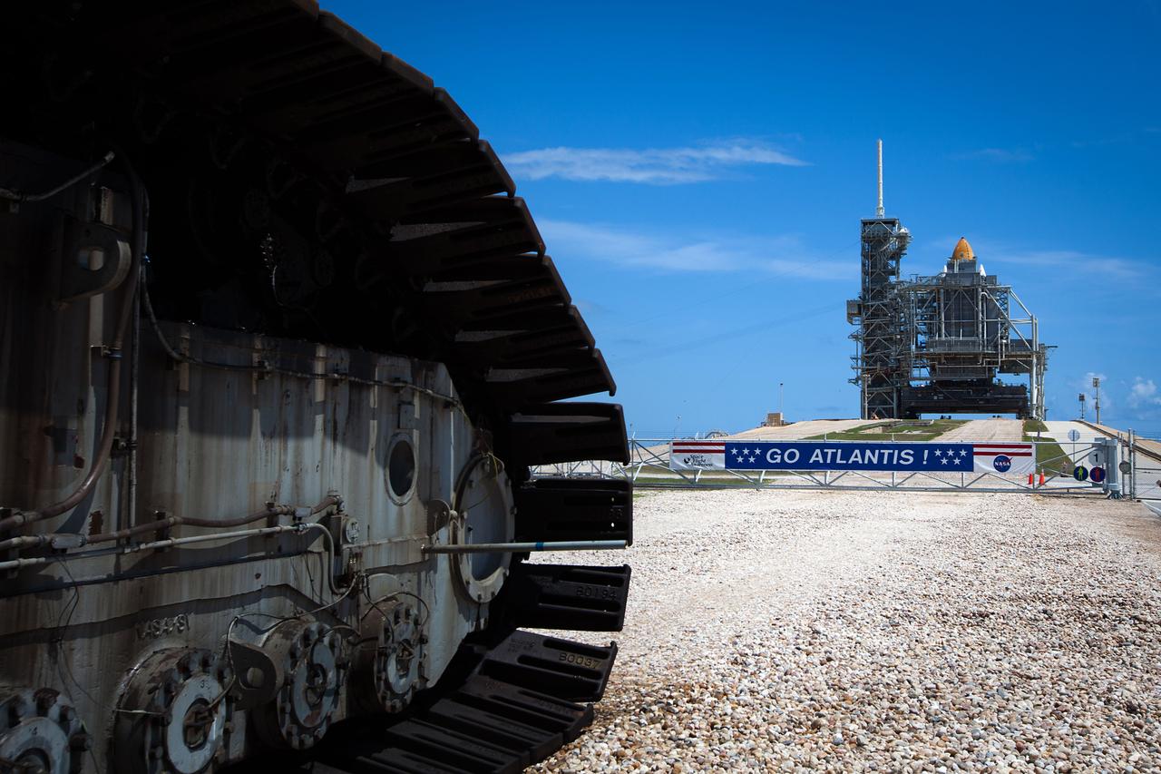 JSC2011-E-059493 (31 May 2011) --- The space shuttle Atlantis is seen in the background on Launch Pad 39A at NASA?s Kennedy Space Center in Florida on May 31, 2011. The crawler/transporter is seen slowly driving away from the launch pad after making its final scheduled delivery of a shuttle.  The orbiter is scheduled to fly the final mission of the Space Shuttle Program, launching on July 8. Photo credit: NASA Photo/Houston Chronicle, Smiley N. Pool