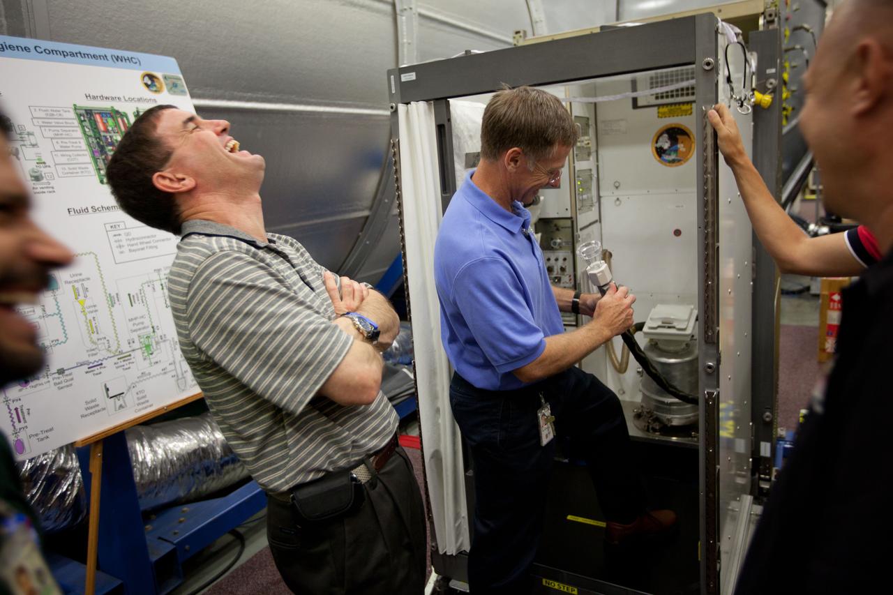 JSC2011-E-060140 (29 June 2011) --- NASA astronaut Rex Walheim laughs with his crewmates as STS-135 commander Chris Ferguson gets a refresher on the use of the waste management system on the International Space Station as the crew trains at NASA?s Johnson Space Center June 29, 2011. The day's training marked the crew's final scheduled sessions in the Space Vehicle Mock-up Facility at JSC. Photo credit: NASA Photo/Houston Chronicle, Smiley N. Pool