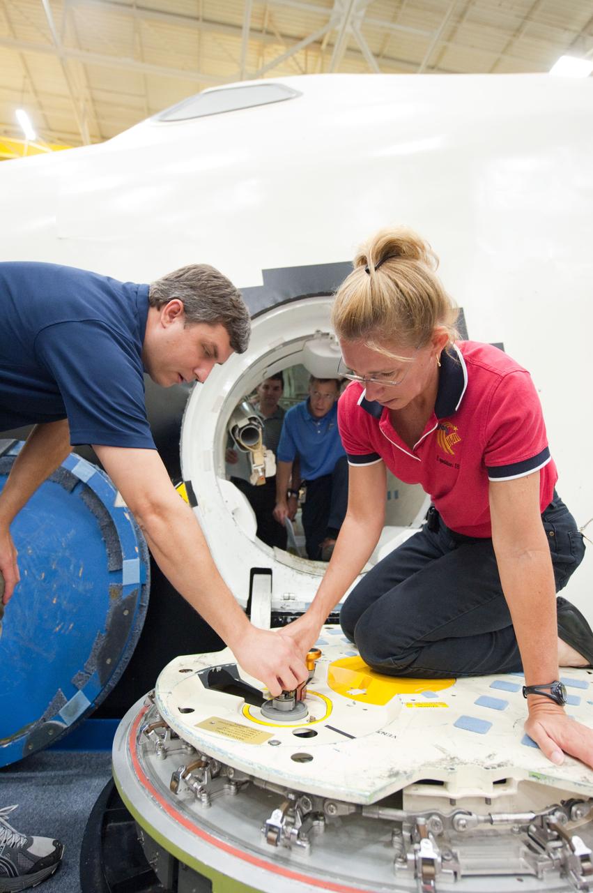 JSC2011-E-060756 (29 June 2011) --- NASA astronaut Sandy Magnus, STS-135 mission specialist, participates in a training session with the crew compartment trainer (CCT-2) in the Space Vehicle Mock-up Facility at NASA's Johnson Space Center. Here, she is briefed on the operation of the hatch. Photo credit: NASA