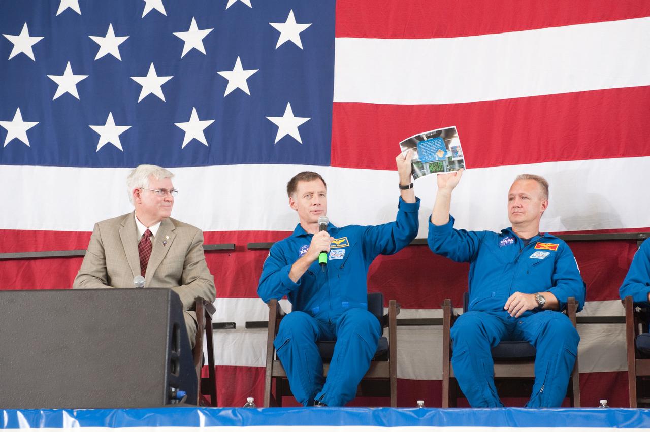 JSC2011-E-070523 (22 July 2011) --- NASA astronauts Chris Ferguson (center), STS-135 commander; and Doug Hurley, pilot, hold up a photo of the plaque that was left in space shuttle Atlantis by the STS-135 crew members during the STS-135 crew return ceremony on July 22, 2011 at Ellington Field near NASA?s Johnson Space Center (JSC). JSC director Michael L. Coats is at left.  Photo credit: NASA