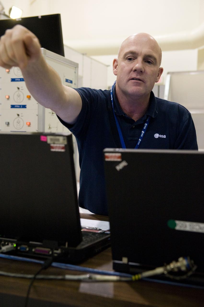 DATE: 9-1-11 LOCATION: Bldg. 5south, SSTF SUBJECT: Expedition 30 crew member and ESA astronaut Andre Kuipers training in SSTF near Columbia module on laptops with trainer Michaela Benda. PHOTOGRAPHER: Lauren Harnett
