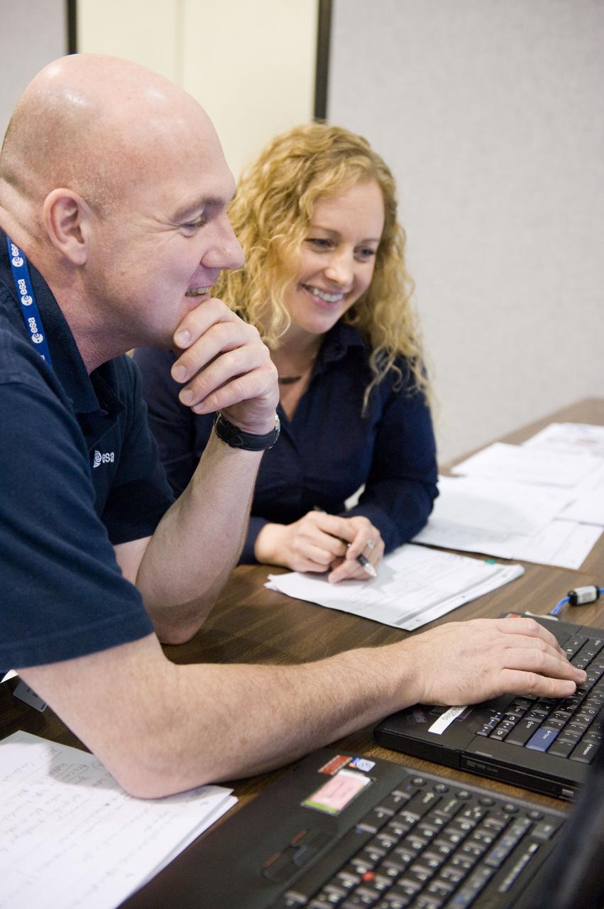 DATE: 9-1-11 LOCATION: Bldg. 5south, SSTF SUBJECT: Expedition 30 crew member and ESA astronaut Andre Kuipers training in SSTF near Columbia module on laptops with trainer Michaela Benda. PHOTOGRAPHER: Lauren Harnett