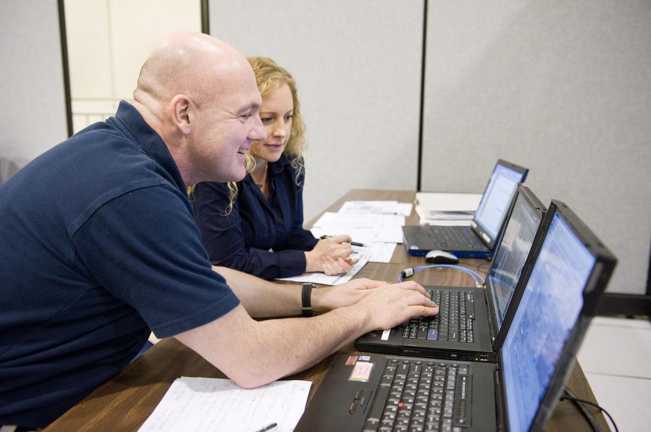 DATE: 9-1-11 LOCATION: Bldg. 5south, SSTF SUBJECT: Expedition 30 crew member and ESA astronaut Andre Kuipers training in SSTF near Columbia module on laptops with trainer Michaela Benda. PHOTOGRAPHER: Lauren Harnett