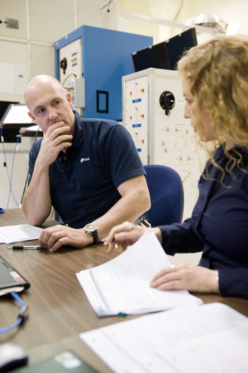DATE: 9-1-11 LOCATION: Bldg. 5south, SSTF SUBJECT: Expedition 30 crew member and ESA astronaut Andre Kuipers training in SSTF near Columbia module on laptops with trainer Michaela Benda. PHOTOGRAPHER: Lauren Harnett