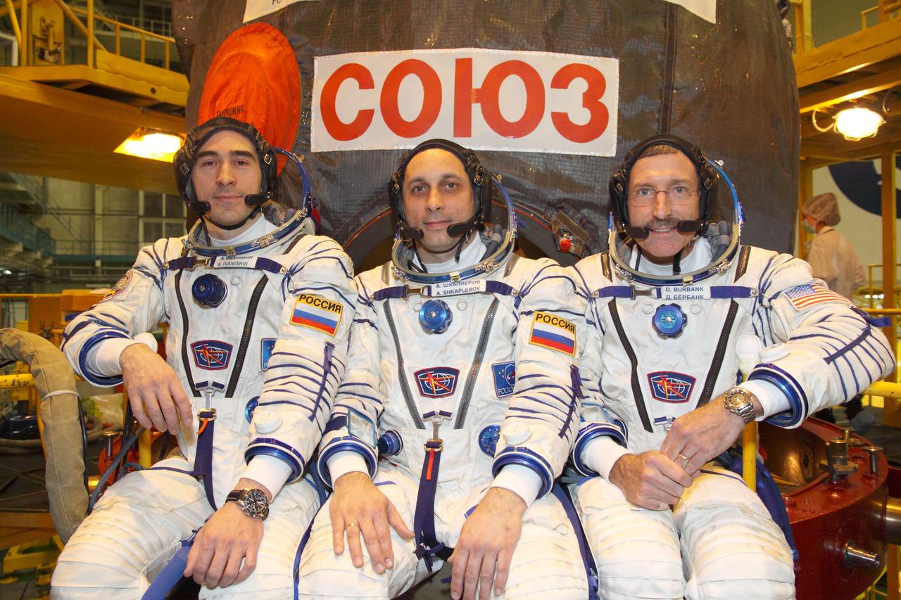At the Integration Facility at the Baikonur Cosmodrome in Kazakhstan, the next trio of residents that will launch to the International Space Station pose for pictures November 1, 2011 following the first of two “fit checks” of their Soyuz TMA-22 spacecraft. Flight Engineer Anatoly Ivanishin (left), Soyuz Commander Anton Shkaplerov (center) and Expedition 30 Commander Dan Burbank of NASA will launch November 14 from Baikonur to spend four months on the orbital laboratory.  November 1, 2011  Credit: NASA/Victor Zelentsov 
