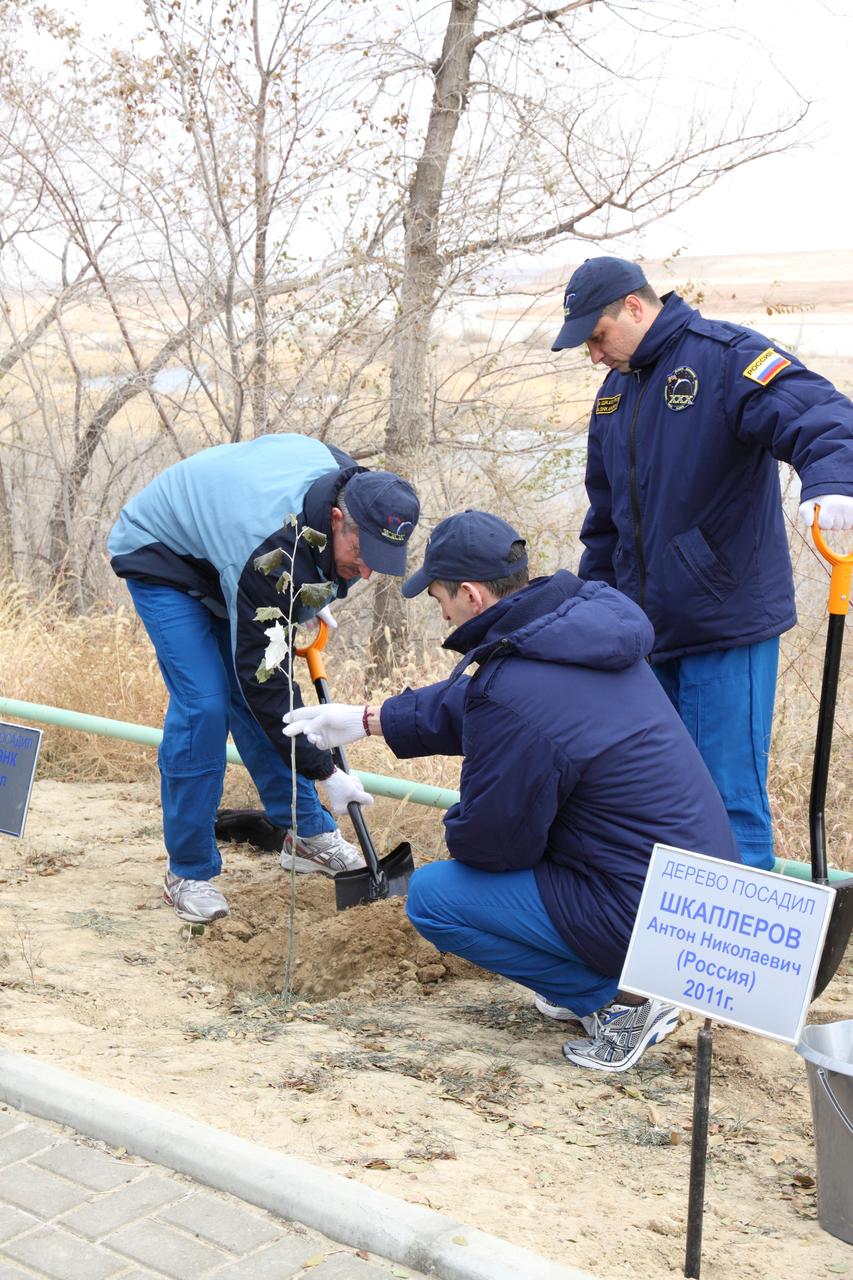Behind their crew quarters at the Cosmonaut Hotel in Baikonur, Kazakhstan, Expedition 30 Commander Dan Burbank of NASA (left), Flight Engineer Anatoly Ivanishin (center) and Soyuz Commander Anton Shkaplerov plant a tree November 8, 2011 as part of the traditional pre-launch ceremonies near their launch site. The trio will launch November 14 in their Soyuz TMA-22 spacecraft bound for the International Space Station. Credit : NASA/Victor Zelentsov