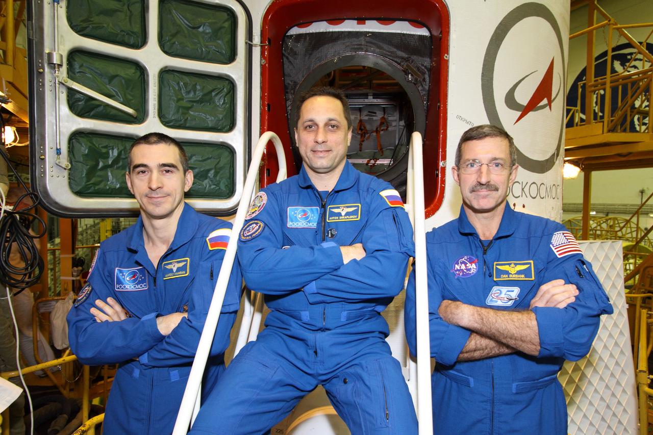 At the Baikonur Cosmodrome in Kazakhstan, Expedition 30 Flight Engineer Anatoly Ivanishin (left), Soyuz Commander Anton Shkaplerov (center) and Expedition 30 Commander Dan Burbank of NASA (right) pose for pictures in front of their Soyuz TMA-22 spacecraft November 9, 2011 as they completed a final inspection of the vehicle in its Integration Facility. The trio are preparing for launch November 14 from Baikonur to the International Space Station.  Credit: NASA/Victor Zelentsov 
