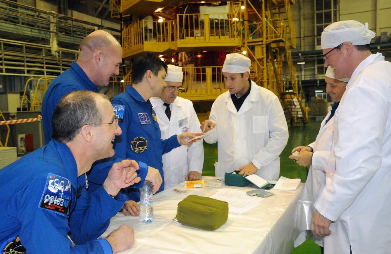 At the Baikonur Cosmodrome in Kazakhstan, the three crewmembers who will round out the Expedition 30 crew on the International Space Station share a light moment with Russian technicians as they inspect crew equipment hardware following a fit check in their Soyuz TMA-03M spacecraft Dec. 9, 2011. NASA Flight Engineer Don Pettit (far left), Flight Engineer Andre Kuipers of the European Space Agency (standing to Pettit’s left) and Soyuz Commander Oleg Kononenko (to Kuipers’ left) will launch Dec. 21 to the station from Baikonur.  Credit: NASA 