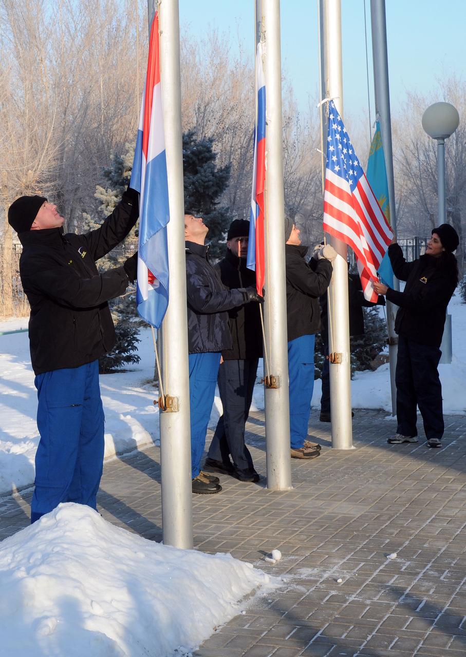 At their crew quarters at the Cosmonaut Hotel in Baikonur, Kazakhstan, Expedition 30 prime and backup crewmembers raise the flags of the Netherlands, the United States and Russia Dec. 10, 2011 in a traditional ceremony as part of their pre-launch preparations. From left to right are Expedition 30 prime Flight Engineer Andre Kuipers of the European Space Agency who is a native of the Netherlands, prime Soyuz Commander Oleg Kononenko, backup Soyuz Commander Yuri Malenchenko, prime NASA Flight Engineer Don Pettit, and backup NASA Flight Engineer Suni Williams. Pettit, Kononenko and Kuipers will launch to the International Space Station on Dec. 21 on their Soyuz TMA-03M spacecraft.  Credit: NASA 