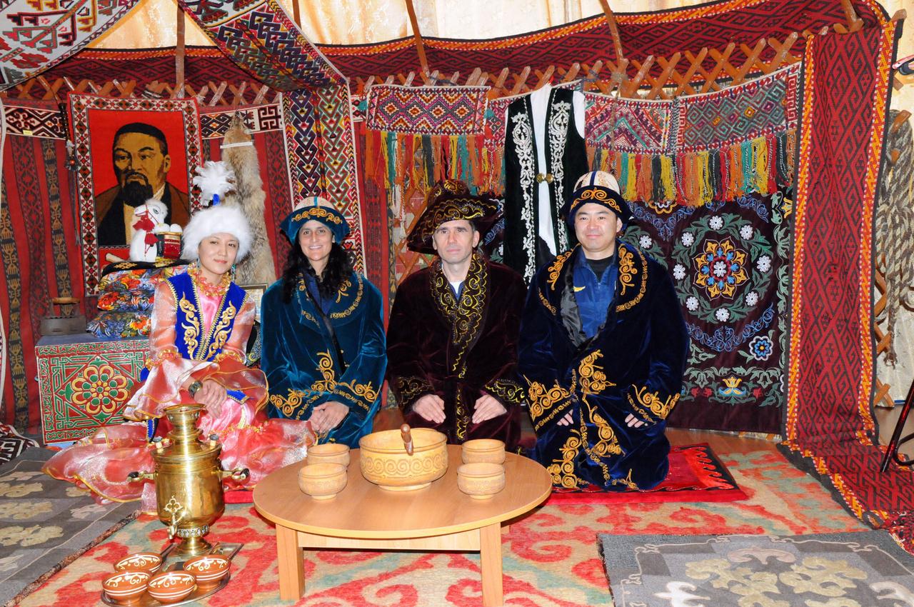 The Expedition 30 backup crewmembers pose for pictures with a Kazakh host inside a model of a primitive Kazakh hut-type house during a tour of a museum near their launch site in Baikonur, Kazakhstan Dec. 11, 2011. Clad in traditional Kazakh garb are backup Flight Engineer Suni Williams of NASA (second from the left), backup Soyuz Commander Yuri Malenchenko and backup Flight Engineer Aki Hoshide of the Japan Aerospace Exploration Agency. The prime crewmembers, NASA’s Don Pettit, Oleg Kononenko and Andre Kuipers of the European Space Agency will launch to the International Space Station Dec. 21 from the Baikonur Cosmodrome in their Soyuz TMA-03M spacecraft.  Credit: NASA 