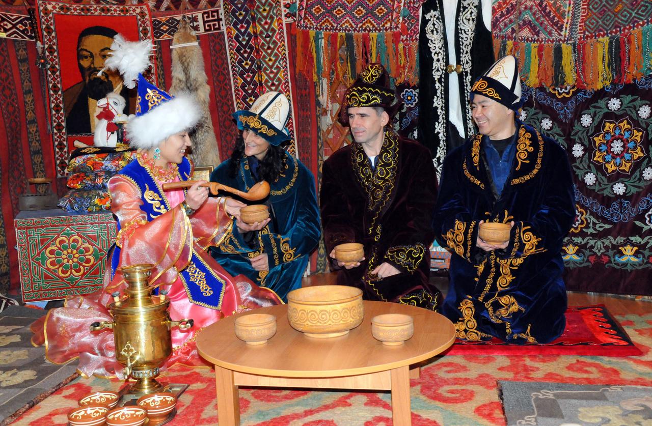 The Expedition 30 backup crewmembers sample local food served by a Kazakh host inside a model of a primitive Kazakh hut-type house during a tour of a museum near their launch site in Baikonur, Kazakhstan Dec. 11, 2011. Clad in traditional Kazakh garb are backup Flight Engineer Suni Williams of NASA (second from the left), backup Soyuz Commander Yuri Malenchenko and backup Flight Engineer Aki Hoshide of the Japan Aerospace Exploration Agency. The prime crewmembers, NASA’s Don Pettit, Oleg Kononenko and Andre Kuipers of the European Space Agency will launch to the International Space Station Dec. 21 from the Baikonur Cosmodrome in their Soyuz TMA-03M spacecraft.  Credit: NASA 