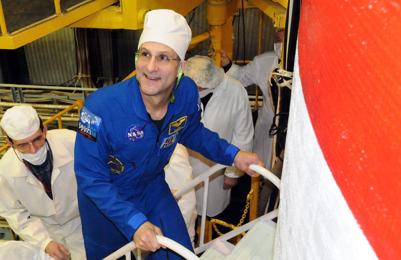 At the Baikonur Cosmodrome in Kazakhstan, Expedition 30 Flight Engineer Don Pettit of NASA flashes a smile as he boards the Soyuz TMA-03M spacecraft in its integration facility December 16, 2011 as part of the final check out of the vehicle before launch. Pettit, Flight Engineer Andre Kuipers of the European Space Agency and Soyuz Commander Oleg Kononenko will launch on Dec. 21 from Baikonur bound for the International Space Station to begin a five and a half month mission.  Credit: NASA 