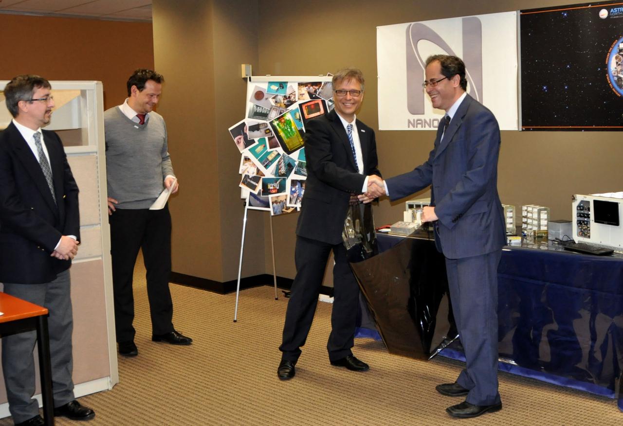JSC2012-E-029874 (14 Feb. 2012) --- During a ceremony on Feb. 14 at the Astrium North America facility in Houston, two principal participants shake hands as a gravitational research centrifuge gets handed over by Astrium ST to NanoRacks LLC representatives. The handshake of Ulrich Kuebler (second right) of Astrium ST and Jeff Manber, managing director of NanoRacks,  symbolizes the working relationship between Astrium ST and NanoRacks, who are working in cooperation with NASA, to deliver the commercial centrifuge facility to the International Space Station. At left are Luca Pieroni of Kayser Italia, one of Astrium's partners in construction the centrifuge, and Achim Schwarzwaelder of Astrium ST . NASA Photo courtesy Astrium North America