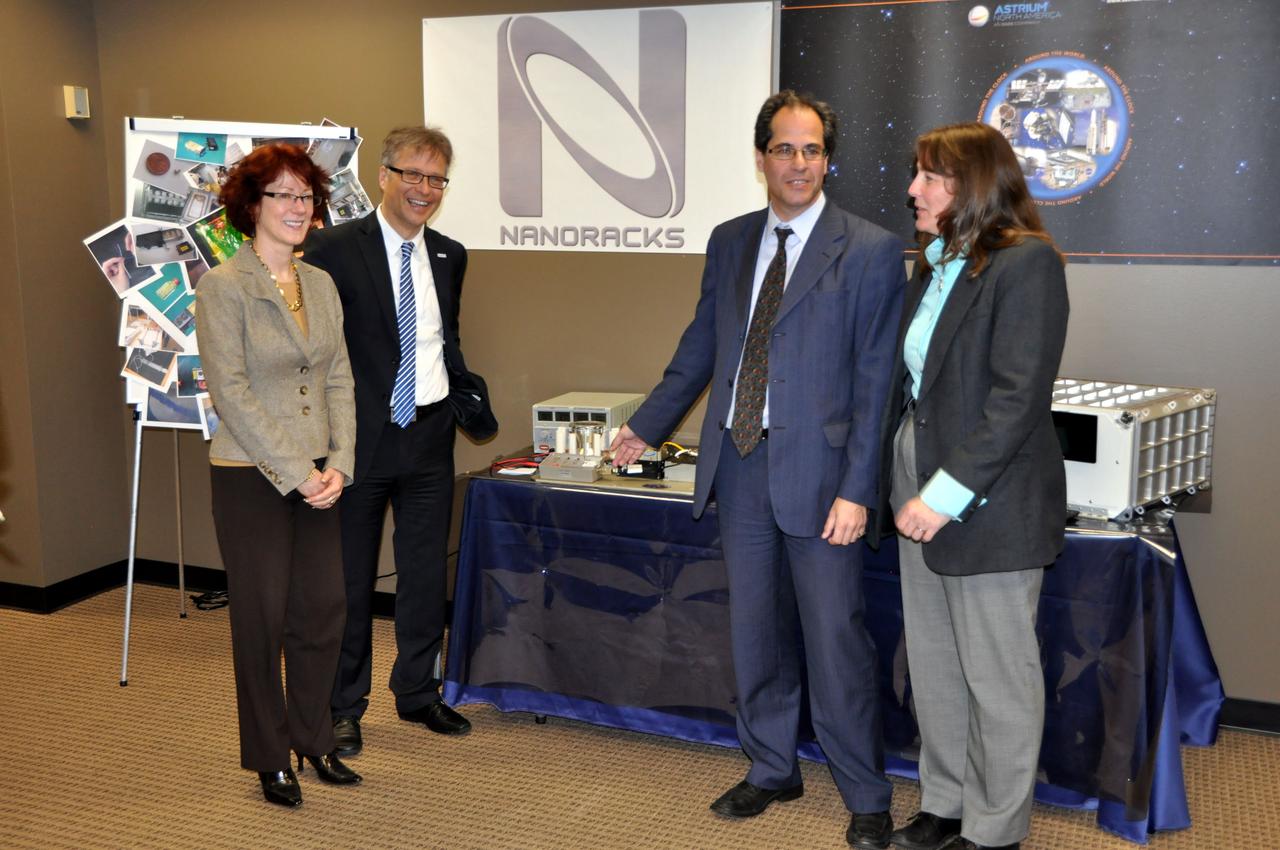 JSC2012-E-029877 (14 Feb. 2012) --- During a ceremony on  Feb. 14, at the Astrium North America facility in Houston, some of the principal participants stand near a gravitational research centrifuge which Astrium ST handed over to NanoRacks LLC representatives. From the left are Jeanne Becker, President, CEO and Executive Director of the Center for the Advancement of Science in Space (CASIS); Ulrich Kuebler of Astrium ST ; Jeff Manber, managing director of NanoRacks; and  Marybeth Edeen, U.S. National Lab manager at NASA?s Johnson Space Center.  NASA Photo courtesy Astrium North America