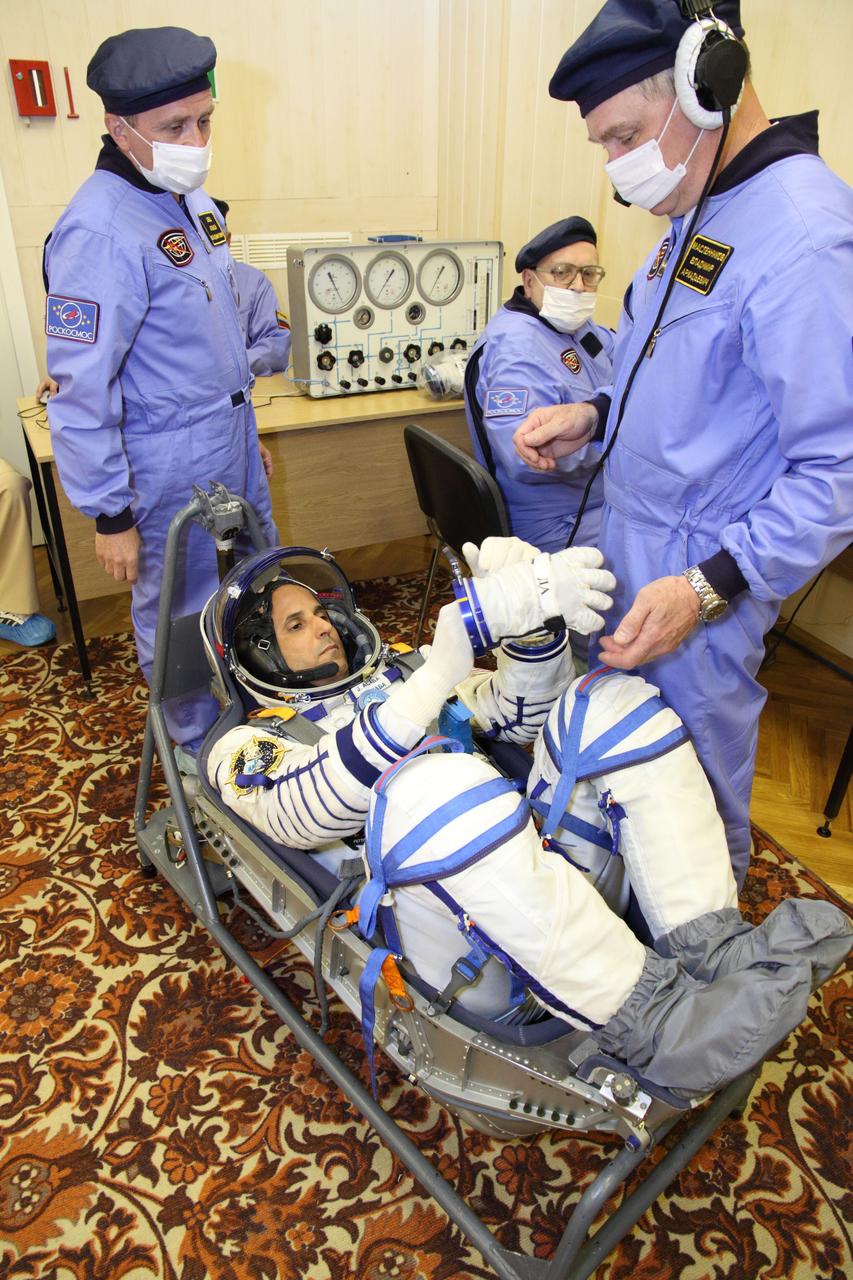 At the Baikonur Cosmodrome in Kazakhstan, Expedition 31/32 Flight Engineer Joe Acaba of NASA conducts pressure and leak checks to his “Sokol” launch and entry suit May 3, 2012 during a suited dress rehearsal of launch day activities as part of the final training he, Soyuz Commander Gennady Padalka and Flight Engineer Sergei Revin are undergoing in advance of their launch May 15 on the Soyuz TMA-04M spacecraft to the International Space Station.  NASA/Victor Zelentsov 