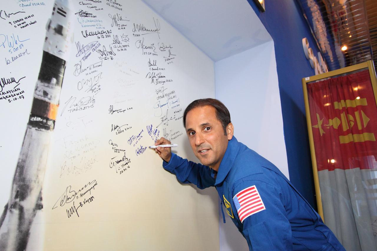 At the historic museum near the launch pad at the Baikonur Cosmodrome in Kazakhstan, Expedition 31/32 Flight Engineer Joe Acaba of NASA adds his name to the “Wall of Signatures” May 11, 2012 during a traditional museum tour prior to his launch May 15 along with Soyuz Commander Gennady Padalka and Flight Engineer Sergei Revin in their Soyuz TMA-04M spacecraft to begin a four-month mission on the International Space Station. The wall, which is adorned with a life-size picture of a Soyuz rocket, is signed by all crewmembers who launch into space on the Russian booster.  NASA/Victor Zelentsov 