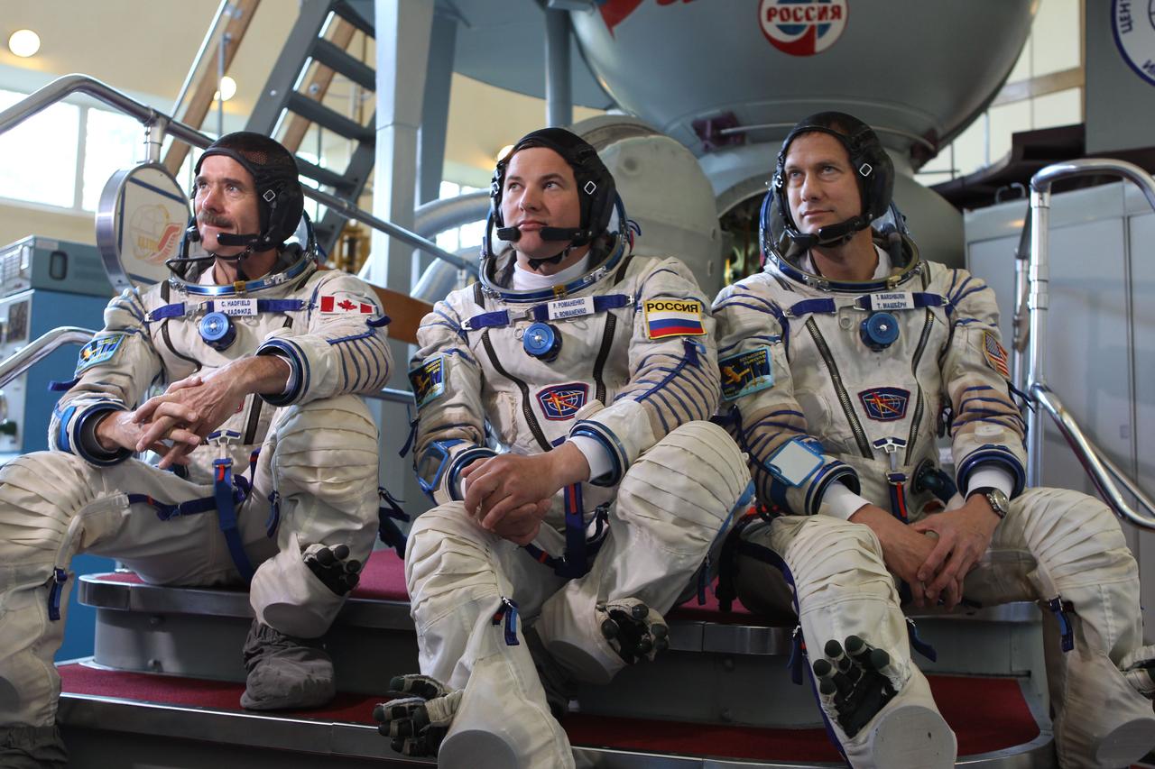 (19 June 2012) --- Expedition 32/33 backup crew members Chris Hadfield of the Canadian Space Agency (left), Soyuz Commander Roman Romanenko and Tom Marshburn of NASA (right) answer questions from the media at a Soyuz vehicle mockup before their final qualification test June 19, 2012 at the Gagarin Cosmonaut Training Center in Star City, Russia. The prime crew, Expedition 32/33 Soyuz Commander Yuri Malenchenko and Flight Engineers Suni Williams of NASA and Aki Hoshide of the Japan Aerospace Exploration Agency practiced similar scenarios nearby in advance of their final approval for launch to the International Space Station July 15 in their Soyuz TMA-05M spacecraft. Photo credit: NASA