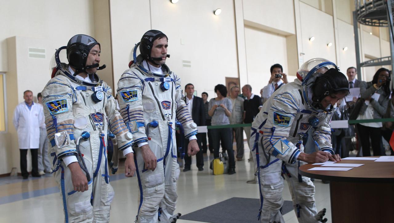 (20 June 2012) --- Expedition 32/33 NASA Flight Engineer Sunita Williams of NASA (right), flanked by Soyuz Commander Yuri Malenchenko (center), and Japan Aerospace Exploration Agency Flight Engineer Aki Hoshide (left), signs an examination card for their final Soyuz vehicle qualification test June 20, 2012 at the Gagarin Cosmonaut Training Center in Star City, Russia. Malenchenko, Williams and Hoshide are scheduled to launch July 15 from the Baikonur Cosmodrome in their Soyuz TMA-05M spacecraft to the International Space Station. Photo credit: NASA/Stephanie Stoll