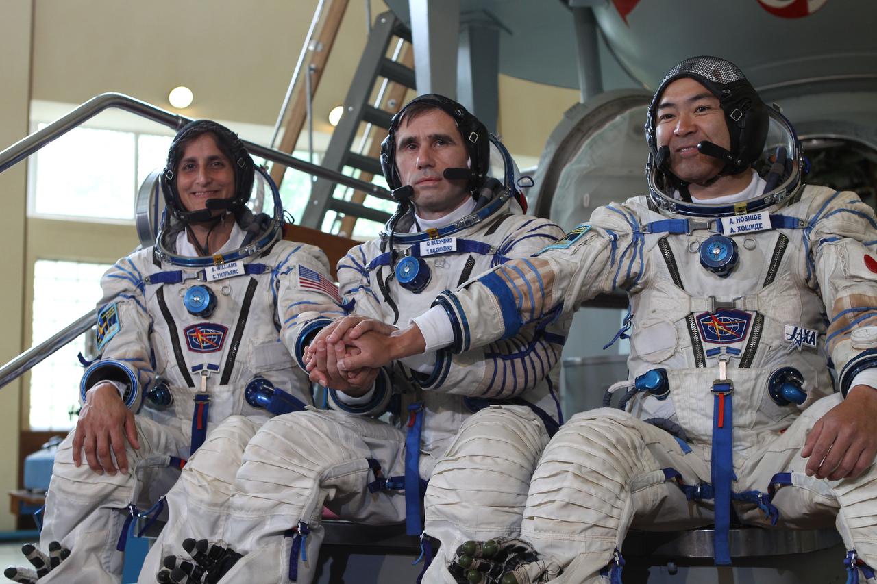 (20 June 2012) --- Expedition 32/33 NASA Flight Engineer Sunita Williams of NASA (left), Soyuz Commander Yuri Malenchenko (center), and Japan Aerospace Exploration Agency Flight Engineer Aki Hoshide (right), pose for photos at a Soyuz vehicle mock-up before their final qualification test June 20, 2012 at the Gagarin Cosmonaut Training Center in Star City, Russia. Malenchenko, Williams and Hoshide are scheduled to launch July 15 from the Baikonur Cosmodrome in their Soyuz TMA-05M spacecraft to the International Space Station.  Photo credit: NASA/Stephanie Stoll 