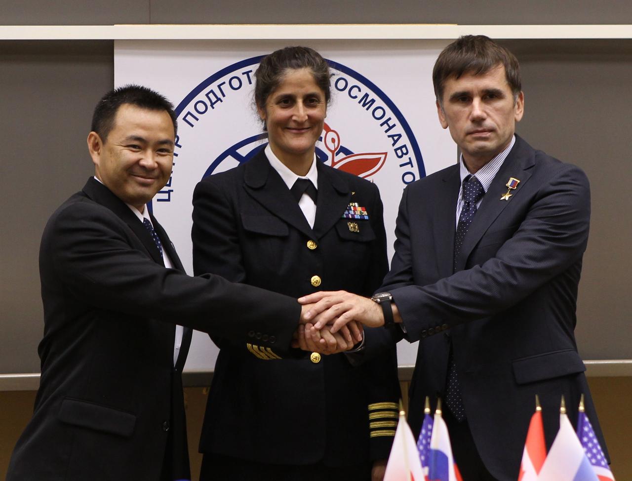 At the Gagarin Cosmonaut Training Center in Star City, Russia, Expedition 32/33 Flight Engineer Aki Hoshide of the Japan Aerospace Exploration Agency (left), NASA Flight Engineer Sunita Williams (center) and Soyuz Commander Yuri Malenchenko grasped hands at the completion of a pre-launch news conference June 22, 2012. The crew will travel to the Baikonur Cosmodrome in Kazakhstan July 2 for final preparations leading to their launch July 15 to the International Space Station in their Soyuz TMA-05M spacecraft.  Credit: NASA/Stephanie Stoll 