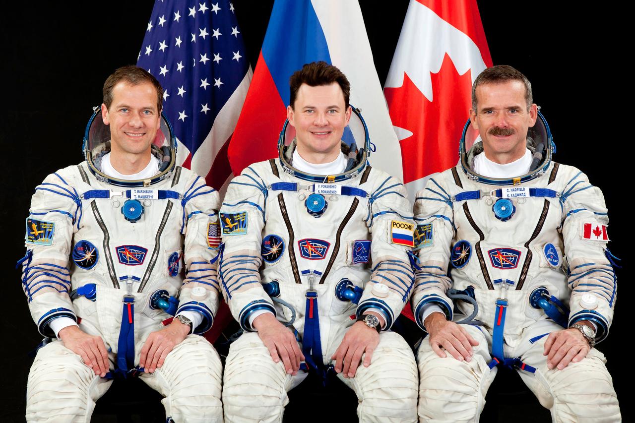 JSC2012-E-096292 (7 June 2012) --- Attired in Russian Sokol launch and entry suits, NASA astronaut Tom Marshburn (left), Russian cosmonaut Roman Romanenko (center) and Canadian Space Agency astronaut Chris Hadfield, all Expedition 32 backup crew members, take a break from training in Star City, Russia to pose for a portrait. Photo credit: Gagarin Cosmonaut Training Center
