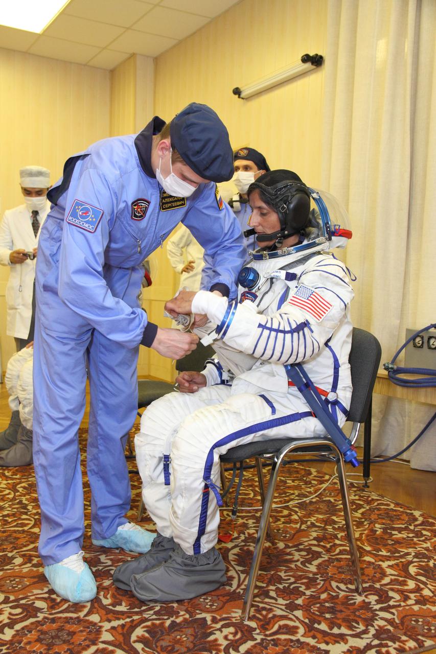 At the Baikonur Cosmodrome in Kazakhstan, Expedition 32/33 Flight Engineer Sunita Williams climbs into her Russian launch and entry suit July 3, 2012 for the suited “fit check” in the Soyuz TMA-05M spacecraft that will launch her, Soyuz Commander Yuri Malenchenko and Flight Engineer Aki Hoshide of the Japan Aerospace Exploration Agency to the International Space Station on July 15.  NASA/Victor Zelentsov 