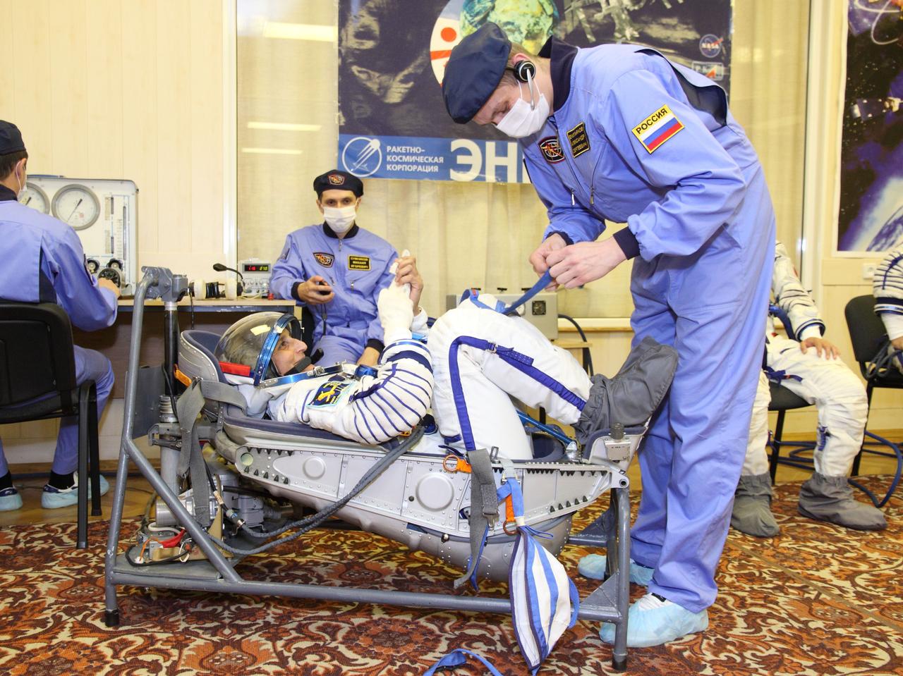At the Baikonur Cosmodrome in Kazakhstan, Expedition 32/33 Flight Engineer Sunita Williams participates in a leak check of her Russian launch and entry suit July 3, 2012 as part of the suited “fit check” of the Soyuz TMA-05M spacecraft that will launch her, Soyuz Commander Yuri Malenchenko and Flight Engineer Aki Hoshide of the Japan Aerospace Exploration Agency to the International Space Station on July 15.  NASA/Victor Zelentsov 
