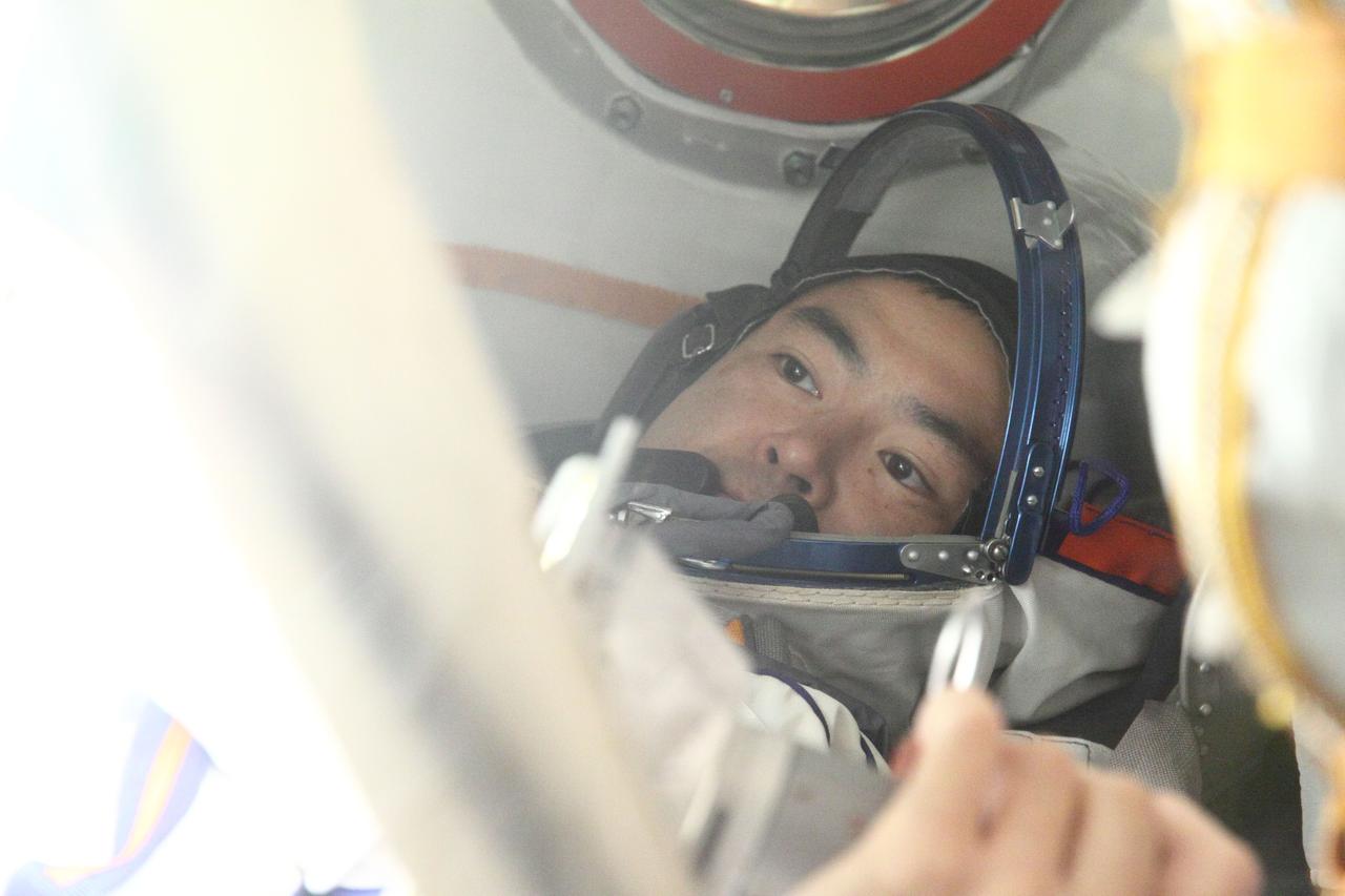 At the Baikonur Cosmodrome in Kazakhstan, Expedition 32/33 Flight Engineer Aki Hoshide of the Japan Aerospace Exploration Agency lies in the Soyuz TMA-05 spacecraft July 3, 2012 during a suited “fit check” of the vehicle that will launch him, Soyuz Commander Yuri Malenchenko and Flight Engineer Sunita Williams of NASA to the International Space Station on July 15.  NASA/Victor Zelentsov 