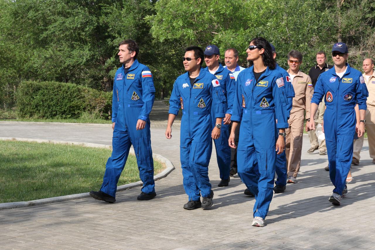 The prime Expedition 32/33 crewmembers take a walk on the grounds of their Cosmonaut Hotel crew quarters in Baikonur, Kazakhstan July 9, 2012 as they continue preparations for their launch July 15 to the International Space Station from the Baikonur Cosmodrome in their Soyuz TMA-05M spacecraft. From left to right in the foreground are Soyuz Commander Yuri Malenchenko, Flight  Engineer Aki Hoshide of the Japan Aerospace Exploration Agency and NASA Flight Engineer Sunita Williams. Backup crewmembers and other personnel are seen accompanying the prime crew.  NASA/Victor Zelentsov 