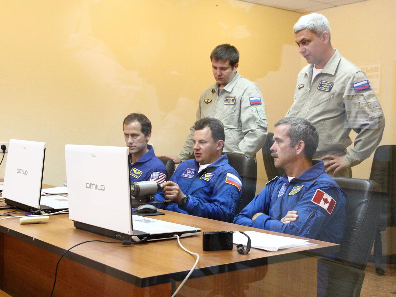 At their Cosmonaut Hotel crew quarters in Baikonur, Kazakhstan, the Expedition 32/33 backup crew members participate in a rendezvous and docking practice session using laptop computer simulators July 9, 2012 as they train for support of the prime crew’s launch July 15 to the International Space Station in the Soyuz TMA-05M spacecraft. From left to right with their instructors are backup Flight Engineer Tom Marshburn of NASA, backup Soyuz Commander Roman Romanenko and backup Flight Engineer Chris Hadfield of the Canadian Space Agency.  NASA/Victor Zelentsov 