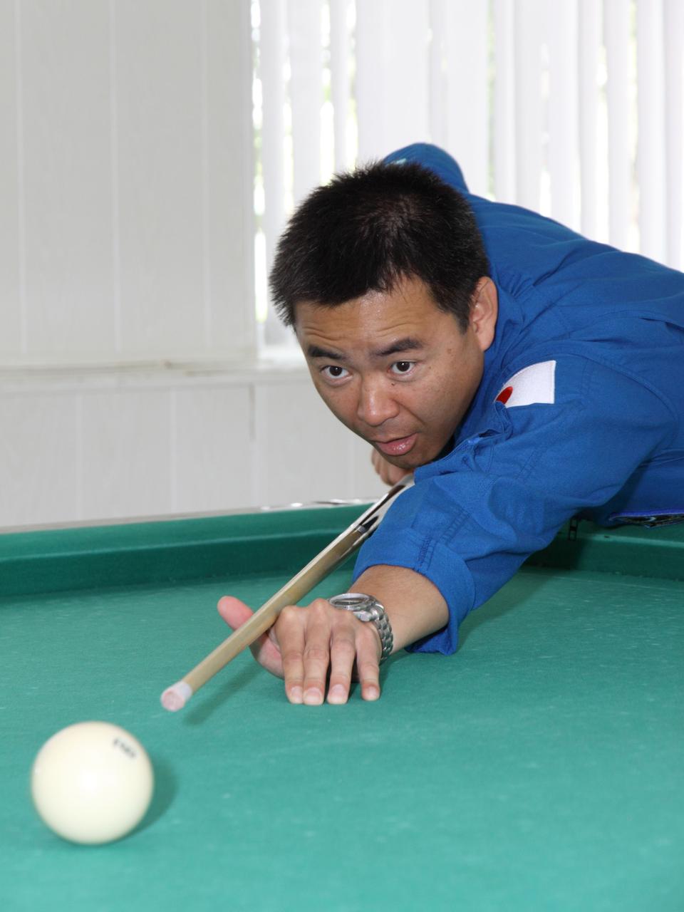 Expedition 32/33 Flight Engineer Aki Hoshide of the Japan Aerospace Exploration Agency gets in a round of billiards at the Cosmonaut Hotel crew quarters in Baikonur, Kazakhstan July 9, 2012 as he prepares for launch July 15 to the International Space Station in the Soyuz TMA-05M spacecraft. Hoshide will launch with Soyuz Commander Yuri Malenchenko and NASA Flight Engineer Sunita Williams.  NASA/Victor Zelentsov 