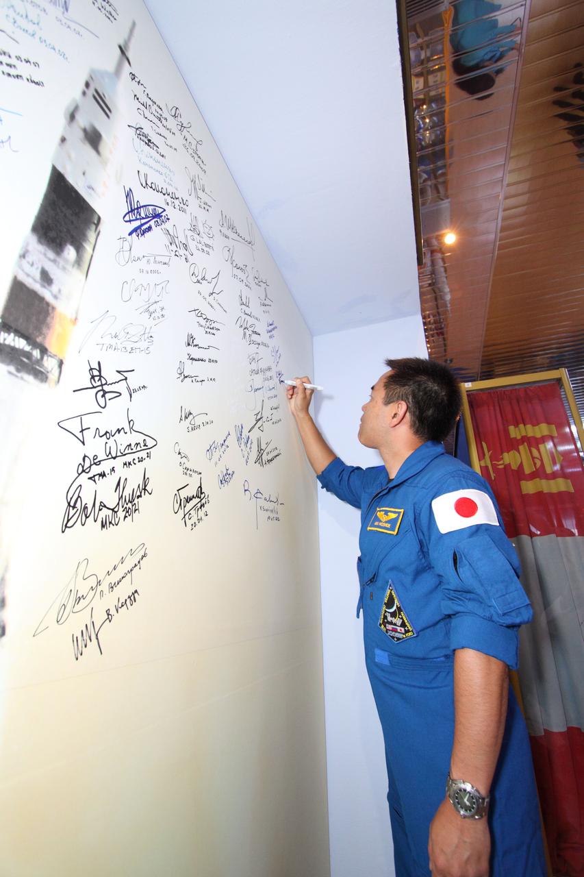 At the Baikonur Cosmodrome in Kazakhstan, Flight Engineer Aki Hoshide of the Japan Aerospace Exploration Agency signs the wall at the Korolev Museum bearing the names of all crewmembers who have launched in Soyuz vehicles July 10, 2012 as he and his crewmates prepare for launch July 15 in their Soyuz TMA-05M spacecraft to the International Space Station. Hoshide will launch with Soyuz Commander Yuri Malenchenko and Flight Engineer Sunita Williams of NASA.  NASA/Victor Zelentsov 