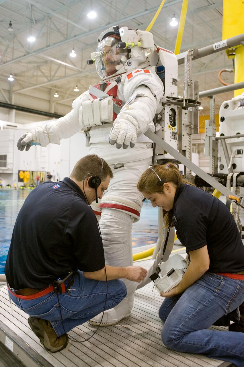 PHOTO DATE:  07-25-12 LOCATION: NBL - Pool Topside    SUBJECT: Expedition 34 crew training during NBL operations. Photograph Kevin Ford and Chris Hadfield interacting, suiting up, being lowered into the water. PHOTOGRAPHER: BILL STAFFORD