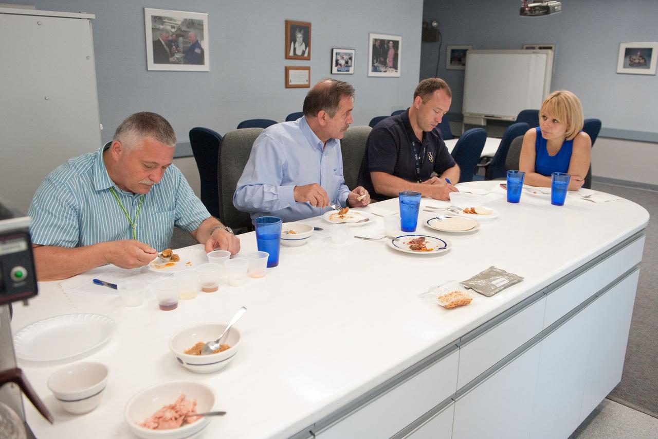 PHOTO DATE: 01 August 2012 LOCATION: Bldg. 17 - JSC Food Lab SUBJECT: Expedition 35/36 Russian cosmonauts during food tasting in JSC Food Lab. Vinogradov, Yurchikin and Misurkin with Russian interpreter. PHOTOGRAPHER: Mark Sowa