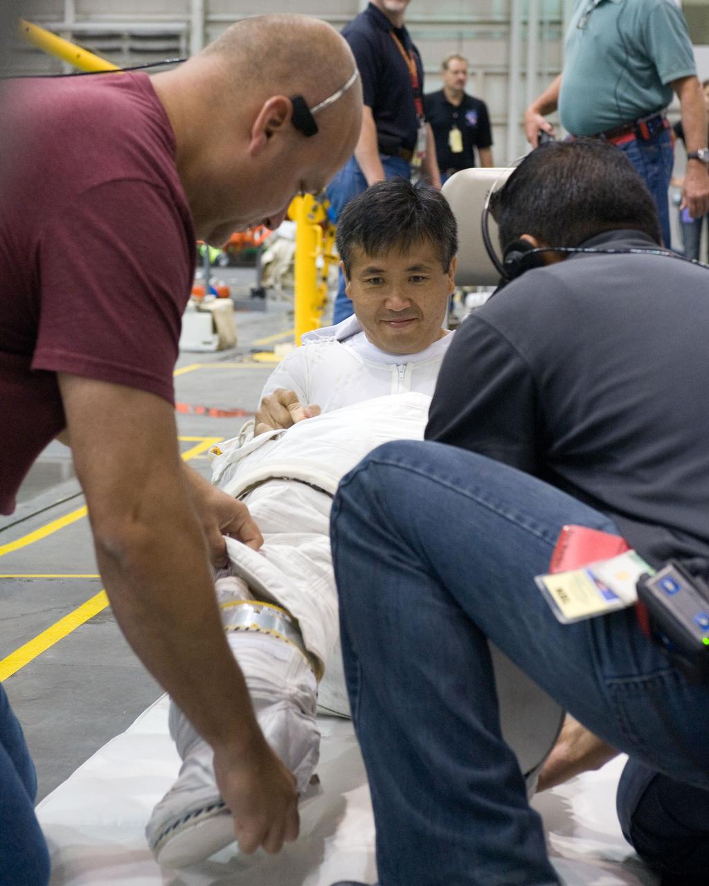 PHOTO DATE:  08-15-12 LOCATION:NBL - Pool Topside    SUBJECT: Expedition 38/39 crew members Koichi Wakata and Mike Hopkins getting suited up and prepped for ISS EVA Maintenance training at the NBL.  PHOTOGRAPHER: BILL STAFFORD