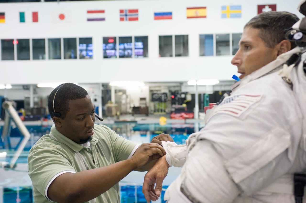 PHOTO DATE:  08-15-12 LOCATION:NBL - Pool Topside    SUBJECT: Expedition 38/39 crew members Koichi Wakata and Mike Hopkins getting suited up and prepped for ISS EVA Maintenance training at the NBL.  PHOTOGRAPHER: BILL STAFFORD