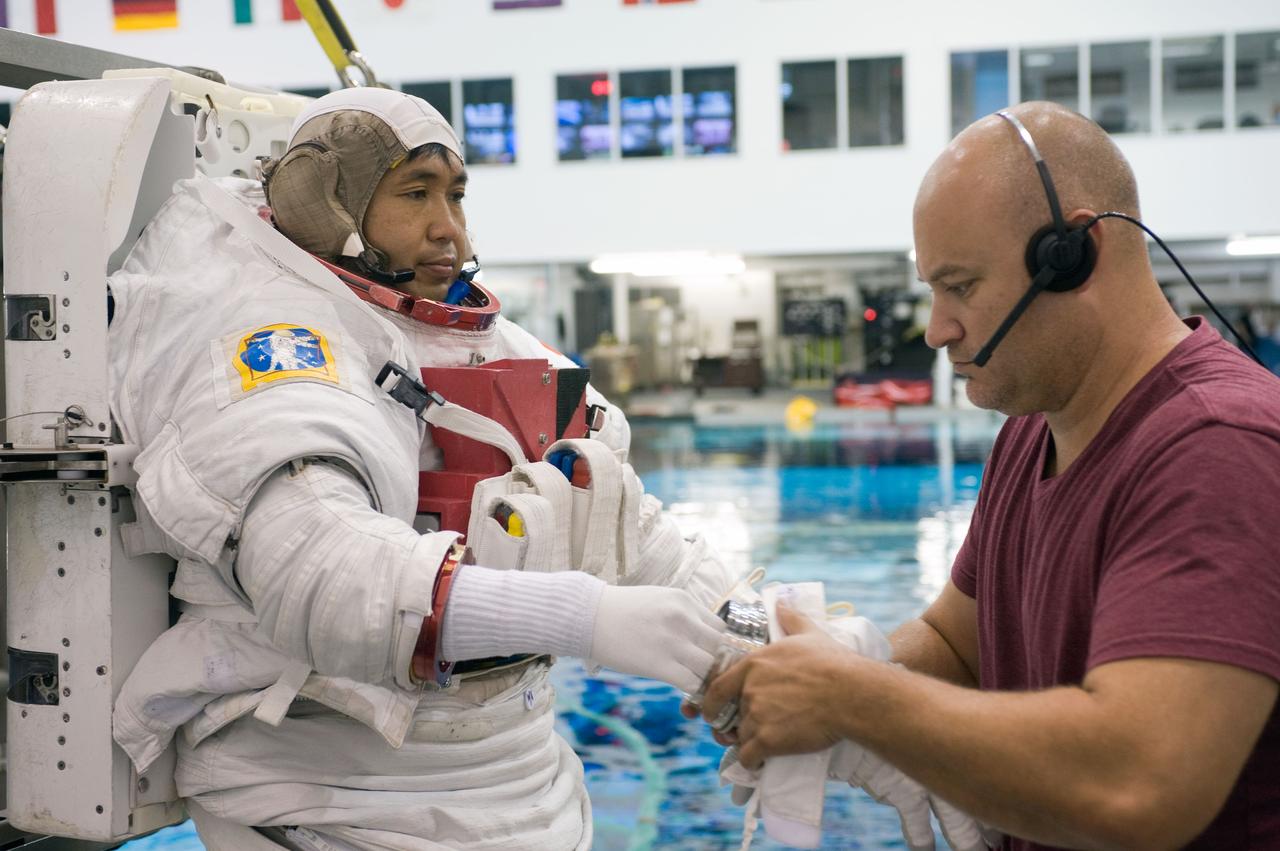 PHOTO DATE:  08-15-12 LOCATION:NBL - Pool Topside    SUBJECT: Expedition 38/39 crew members Koichi Wakata and Mike Hopkins getting suited up and prepped for ISS EVA Maintenance training at the NBL.  PHOTOGRAPHER: BILL STAFFORD