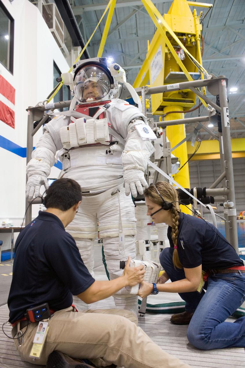 PHOTO DATE:  08-15-12 LOCATION:NBL - Pool Topside    SUBJECT: Expedition 38/39 crew members Koichi Wakata and Mike Hopkins getting suited up and prepped for ISS EVA Maintenance training at the NBL.  PHOTOGRAPHER: BILL STAFFORD
