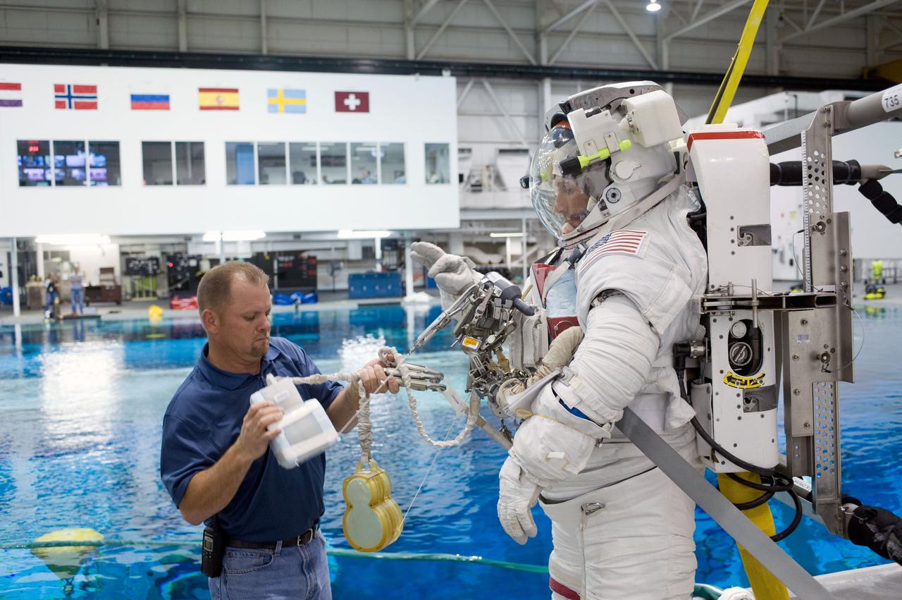PHOTO DATE:  08-15-12 LOCATION:NBL - Pool Topside    SUBJECT: Expedition 38/39 crew members Koichi Wakata and Mike Hopkins getting suited up and prepped for ISS EVA Maintenance training at the NBL.  PHOTOGRAPHER: BILL STAFFORD