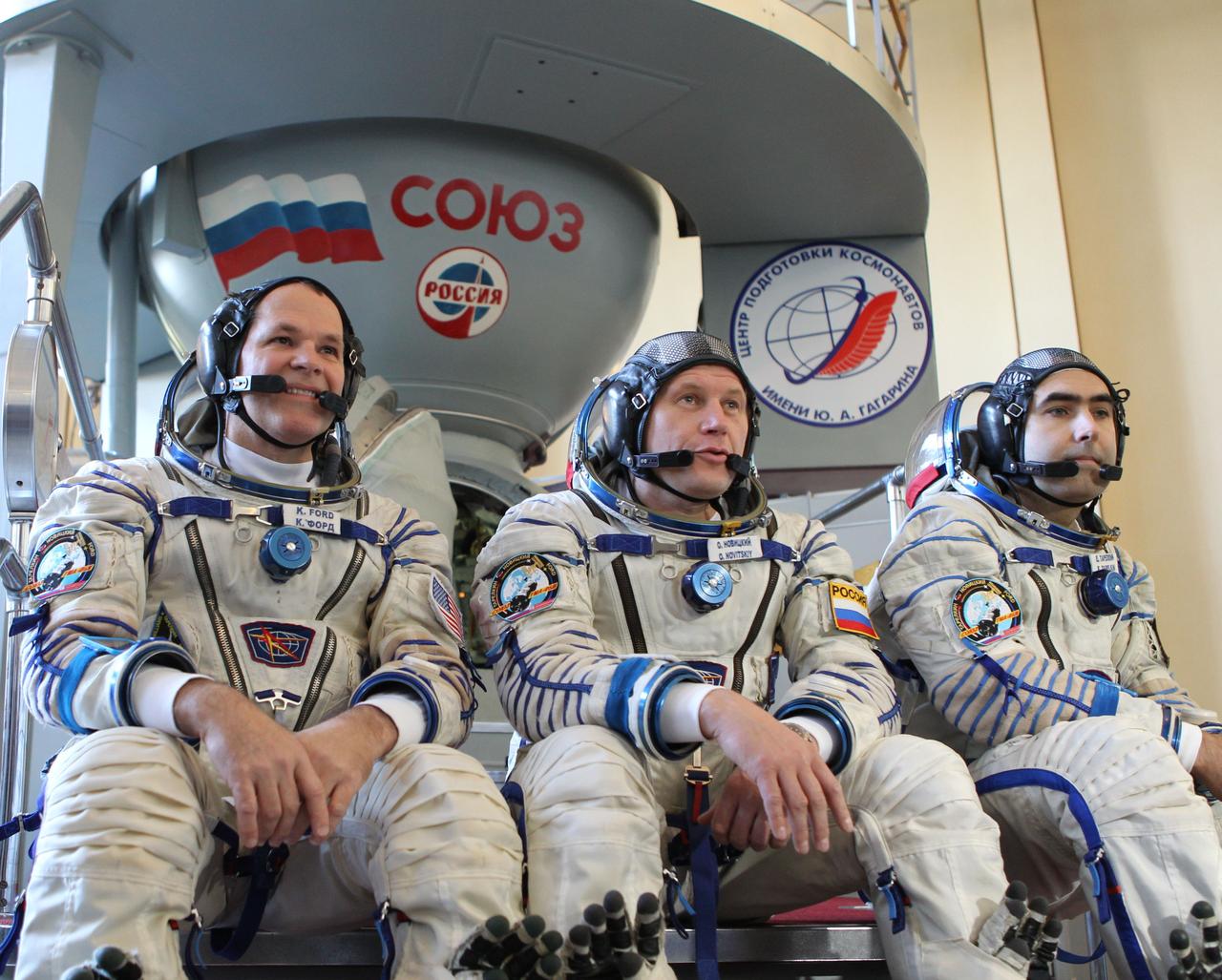 At the Gagarin Cosmonaut Training Center in Star City, Russia, Expedition 33/34 prime crewmembers Flight Engineer Kevin Ford of NASA (left), Soyuz Commander Oleg Novitskiy (center) and Flight Engineer Evgeny Tarelkin (right) answer questions from reporters in front of a Soyuz vehicle mockup during the second day of final qualification exams September 21, 2012. The exams will lead to their launch October 23 in the Soyuz TMA-06M spacecraft from the Baikonur Cosmodrome in Kazakhstan for a five-month stay on the International Space Station.Photo Credit: Stephanie Stoll/NASA