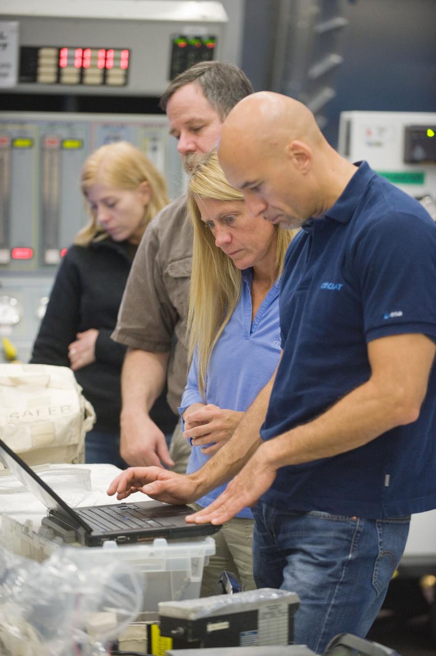 PHOTO DATE:  10-09-12 LOCATION:   Bldg. 9NW - ISS Mockups  SUBJECT:  Expedition 37 (Soyuz 35) crew members Karen Nyberg and Luca Parmitano during ISS EVA P/P training in the ISS airlock with instructor Regan Cheney. PHOTOGRAPHER: BILL STAFFORD