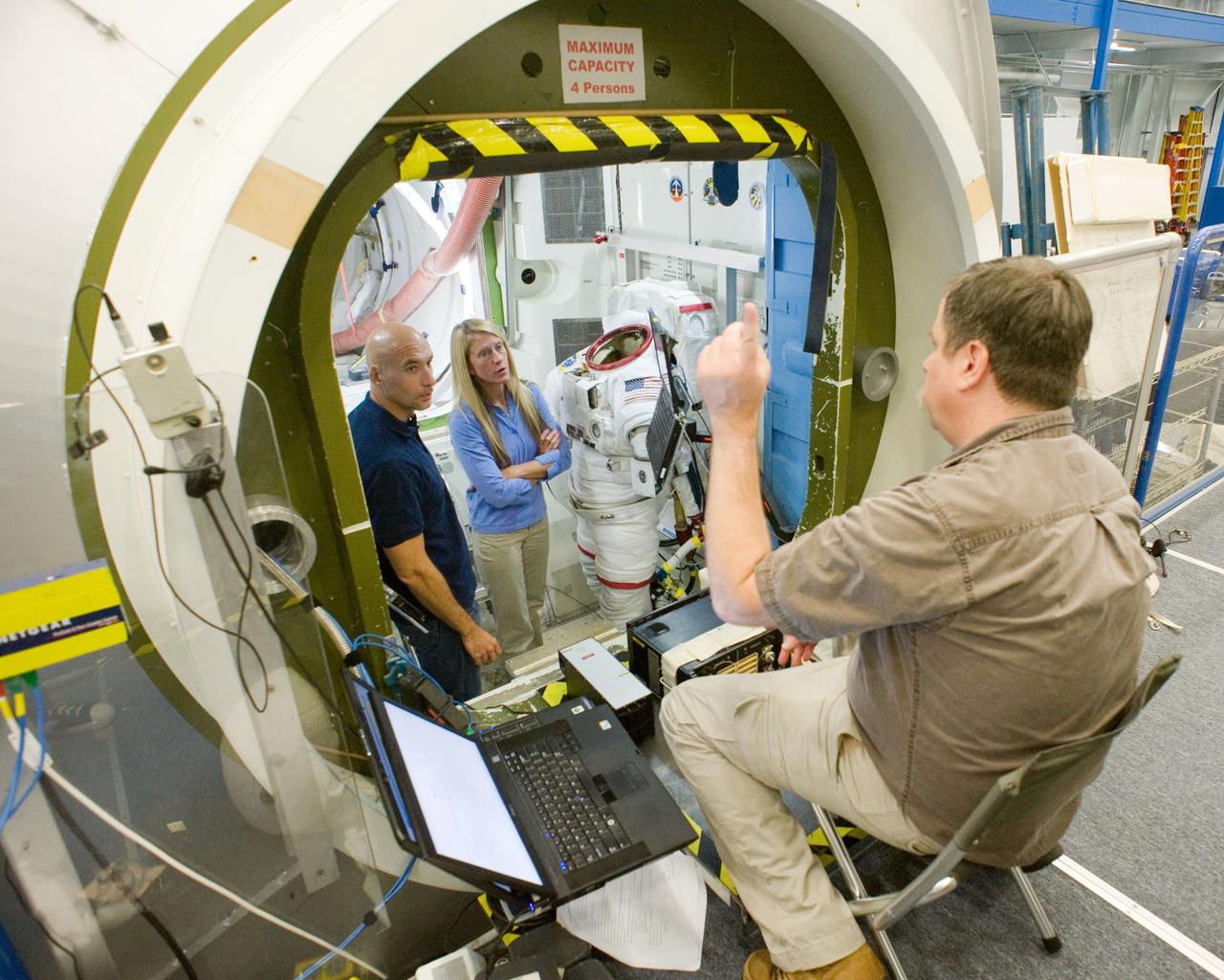 PHOTO DATE:  10-09-12 LOCATION:   Bldg. 9NW - ISS Mockups  SUBJECT:  Expedition 37 (Soyuz 35) crew members Karen Nyberg and Luca Parmitano during ISS EVA P/P training in the ISS airlock with instructor Regan Cheney. PHOTOGRAPHER: BILL STAFFORD