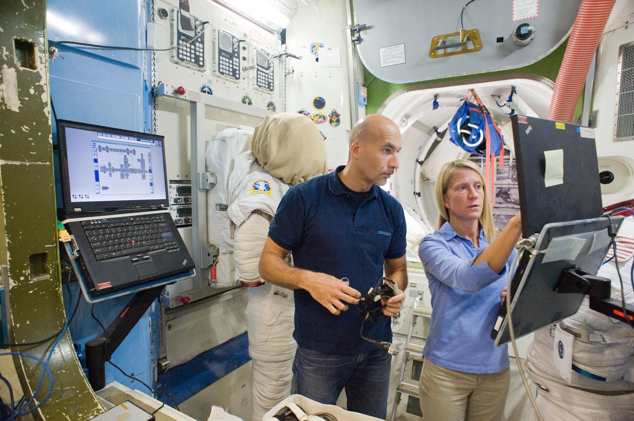 PHOTO DATE:  10-09-12 LOCATION:   Bldg. 9NW - ISS Mockups  SUBJECT:  Expedition 37 (Soyuz 35) crew members Karen Nyberg and Luca Parmitano during ISS EVA P/P training in the ISS airlock with instructor Regan Cheney. PHOTOGRAPHER: BILL STAFFORD