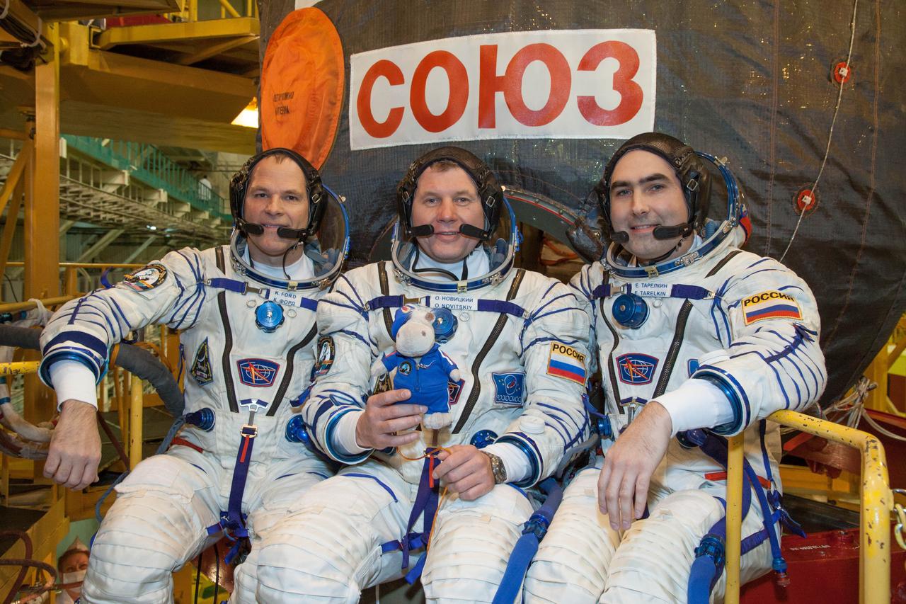 At the Baikonur Cosmodrome in Kazakhstan, the Expedition 33/34 crew posed for pictures October 10, 2012 in front of their Soyuz TMA-06M spacecraft during the first of two “fit check” dress rehearsal sessions. NASA Flight Engineer Kevin Ford (left), Soyuz Commander Oleg Novitskiy (center) and Flight Engineer Evgeny Tarelkin (right) are in the final phase of their training for launch October 23 for a five-month mission on the International Space Station. Novitskiy is holding a toy hippopotamus that will serve as a “zero-g” indicator over his head while he is strapped into the center seat of the descent module section of the Soyuz during its nine minute climb from the launch pad to orbit. NASA/Victor Zelentsov
