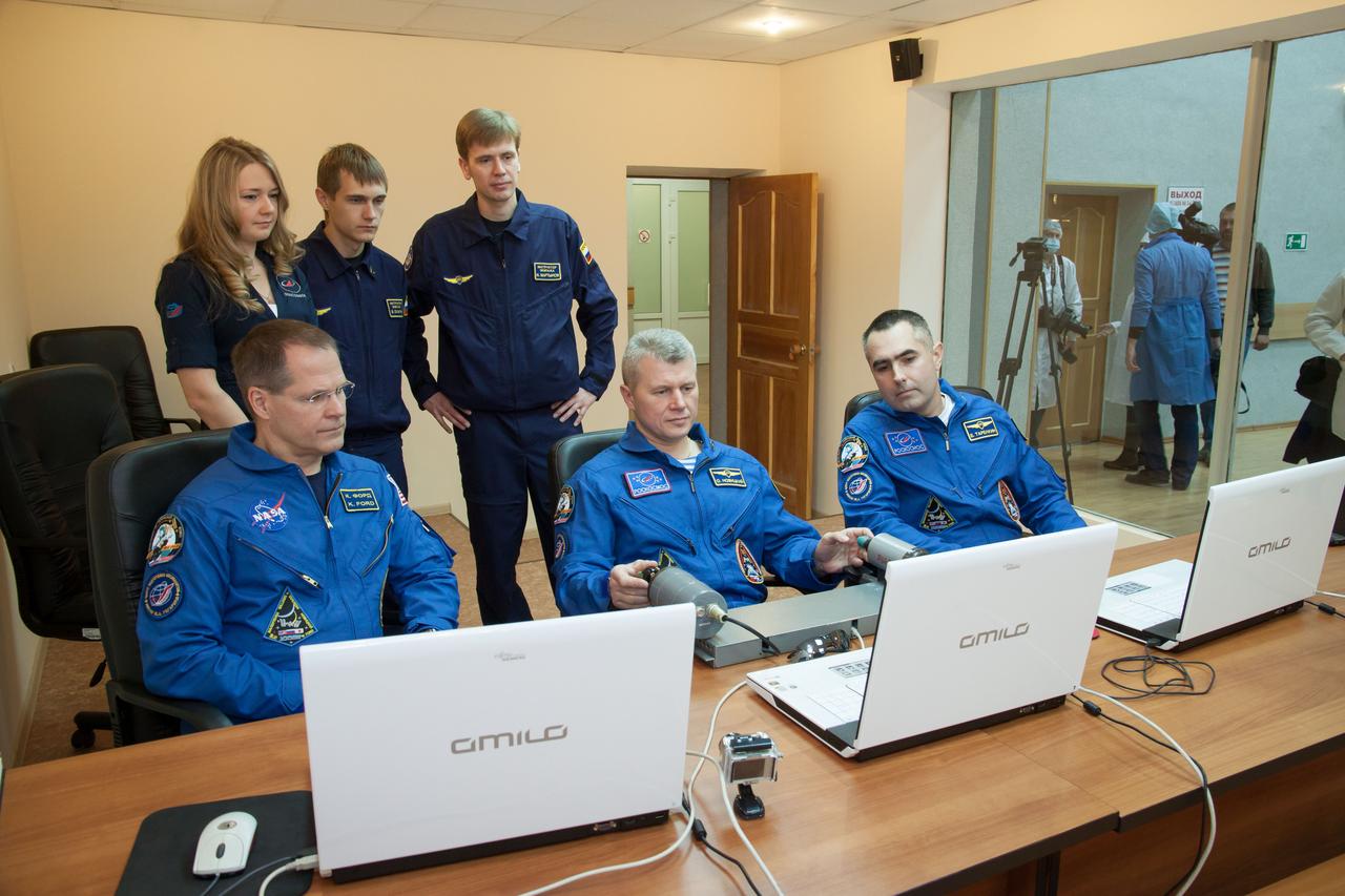 At the Cosmonaut Hotel crew quarters in Baikonur, Kazakhstan, Expedition 33/34 Soyuz Commander Oleg Novitskiy (center) practices docking techniques on a laptop computer simulator as Gagarin Cosmonaut Training Center instructors look on October 17, 2012. Joining Novitskiy are Flight Engineer Kevin Ford of NASA (left) and Flight Engineer Evgeny Tarelkin (right) as they prepare for launch October 23 to the International Space Station in their Soyuz TMA-06M spacecraft. The trio will spend five months on the orbital laboratory. NASA/Victor Zelentsov