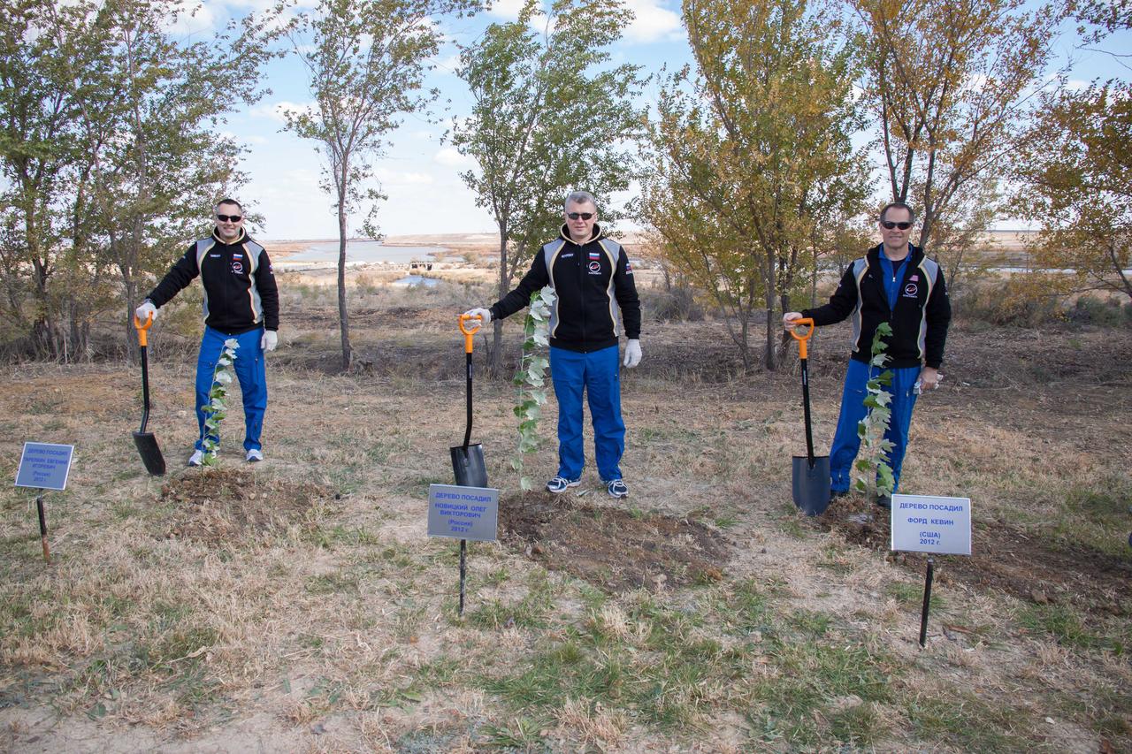 Fulfilling a long-standing pre-launch tradition, Expedition 33/34 Flight Engineer Evgeny Tarelkin (left), Soyuz Commander Oleg Novitskiy (center) and Flight Engineer Kevin Ford of NASA (right) stand by trees they planted in their names behind the Cosmonaut Hotel crew quarters in Baikonur, Kazakhstan October 17, 2012. The trio are preparing for launch October 23 in their Soyuz TMA-06M spacecraft to spend five months on the International Space Station. NASA/Victor Zelentsov